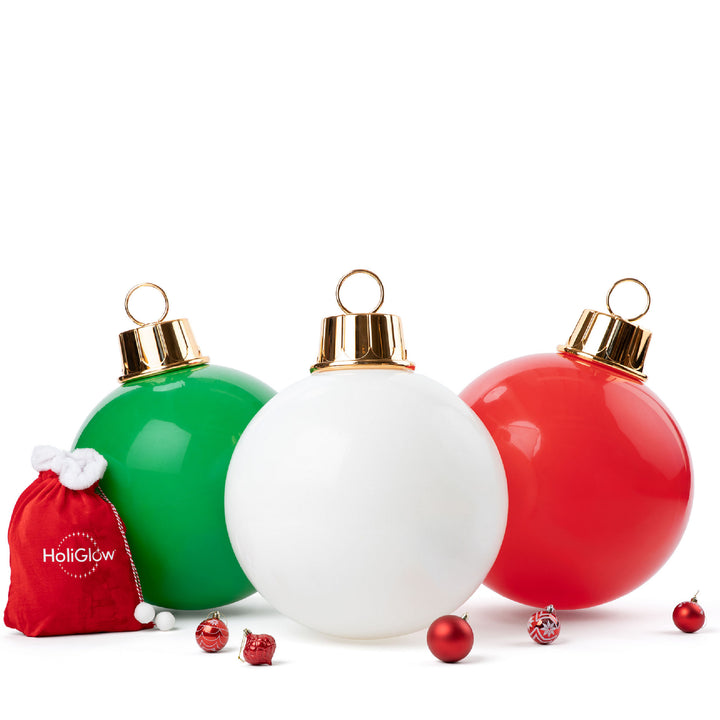 Three Christmas ornaments (green, white, red) with a small red bag labeled 'HoliGlow' on a white background.