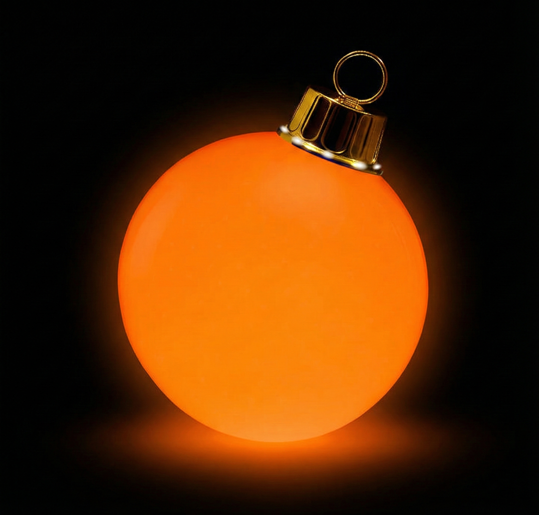 Glowing orange Christmas ornament on a black background