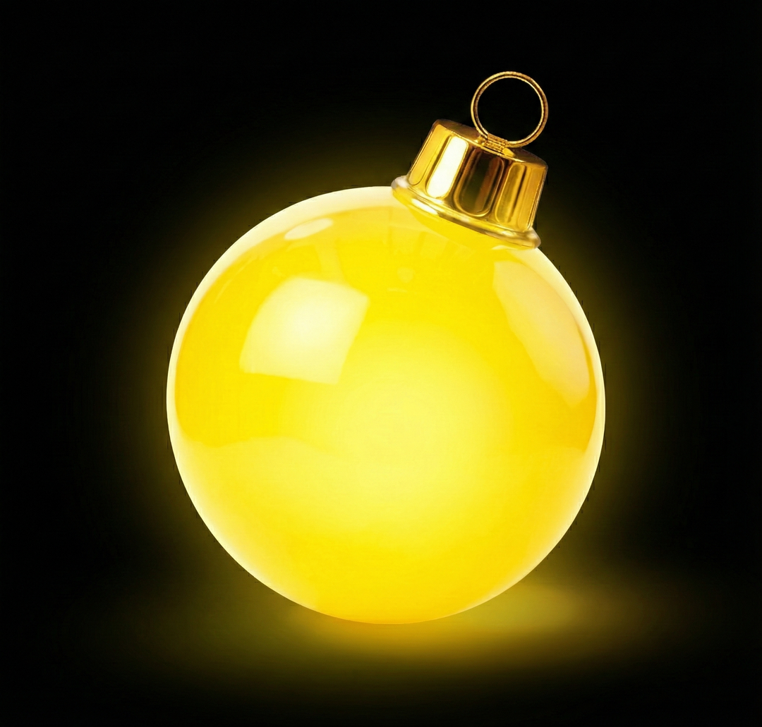 Yellow Christmas ornament with gold cap on a black background